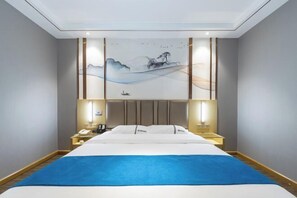 A hotel room with a large bed, bedside tables, a wall-mounted artwork, and a ceiling light fixture. - Rui Jia Business Hotel (Jingzhou)