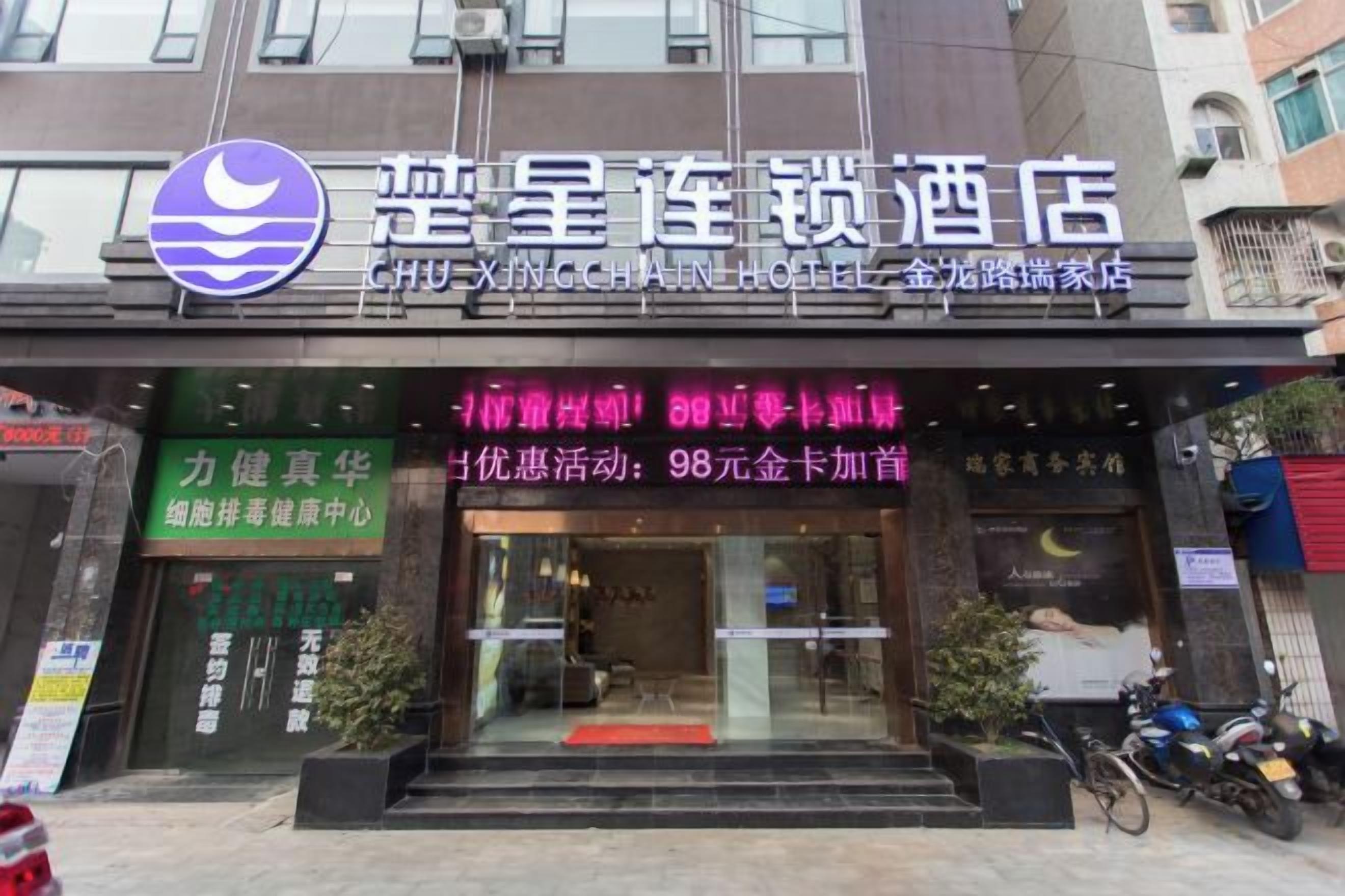 A hotel entrance with a signboard displaying amenities and a logo.