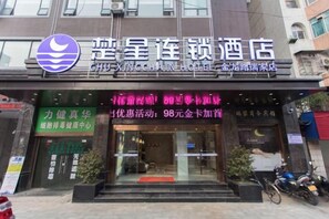 A hotel entrance with a signboard displaying amenities and a logo.