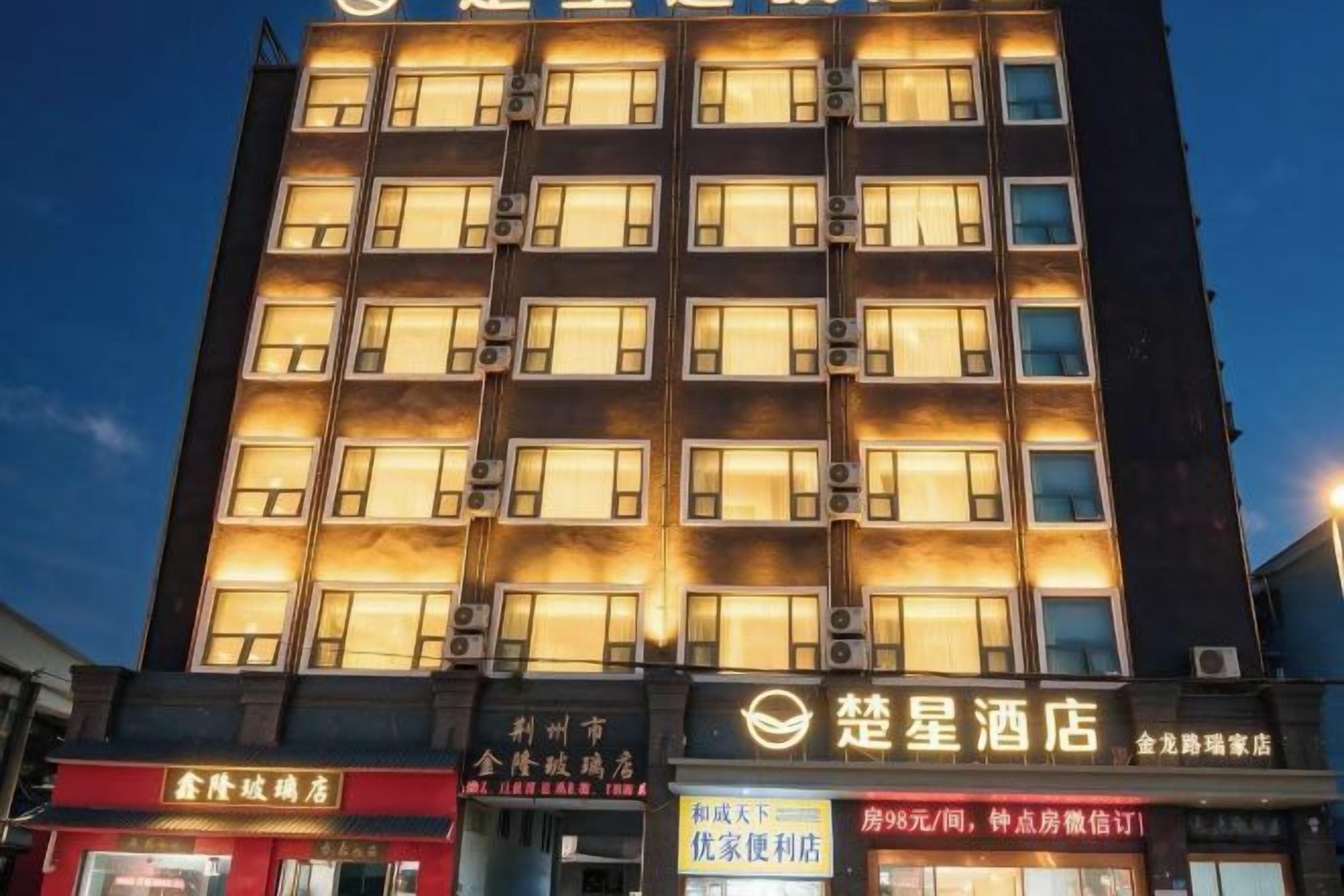 Ein mehrstöckiges Hotel mit beleuchteten Fenstern und Beschilderung, die verschiedene Annehmlichkeiten und Dienstleistungen anzeigt.