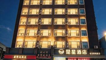 A multi-story hotel with illuminated windows and signage indicating various amenities and services.