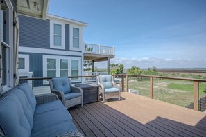 Una terraza con mobiliario exterior, barandilla y vistas al paisaje.