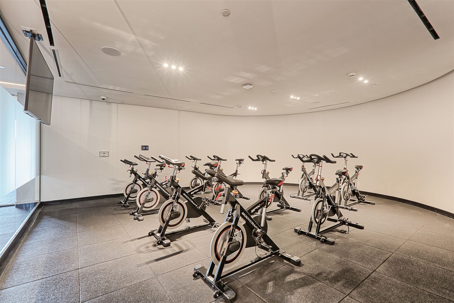 Un gimnasio con varias bicicletas estáticas dispuestas en filas.