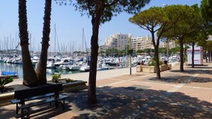 A marina with boats, a bench, and trees.