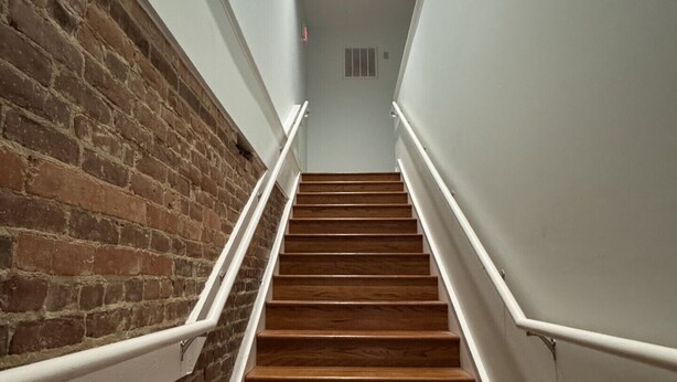 A staircase with wooden steps and white handrails, leading to a landing with a light fixture. - Stylish 2-bedroom apartment with WiFi, AC in fabulous downtown French Lick (French Lick)