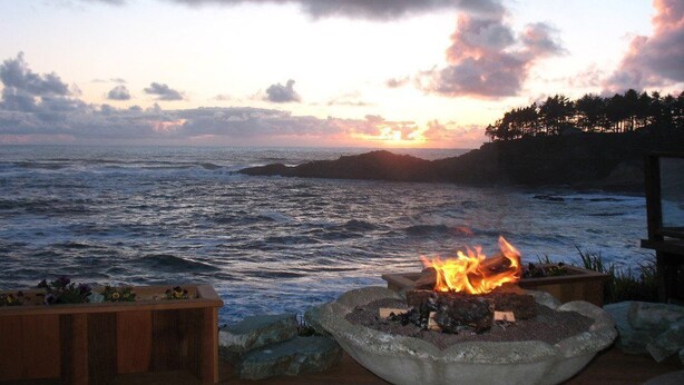 A fire pit with a view of the ocean at sunset. - Ocean Garden Suite at Whales Rendezvous (Depoe Bay)
