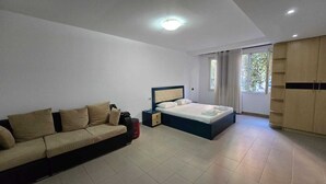 Une chambre à coucher moderne avec un lit, un canapé et une armoire.