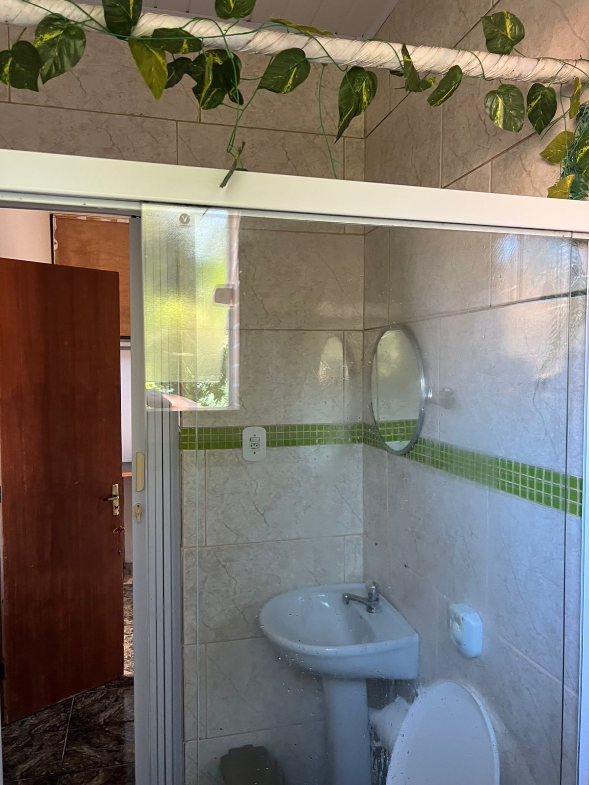 Une salle de bain avec une douche à parois de verre, un lavabo et des toilettes.