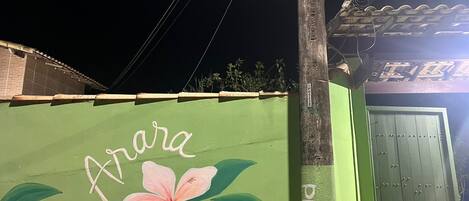 A green building with a painted flower and the name "Arara" on the side.
