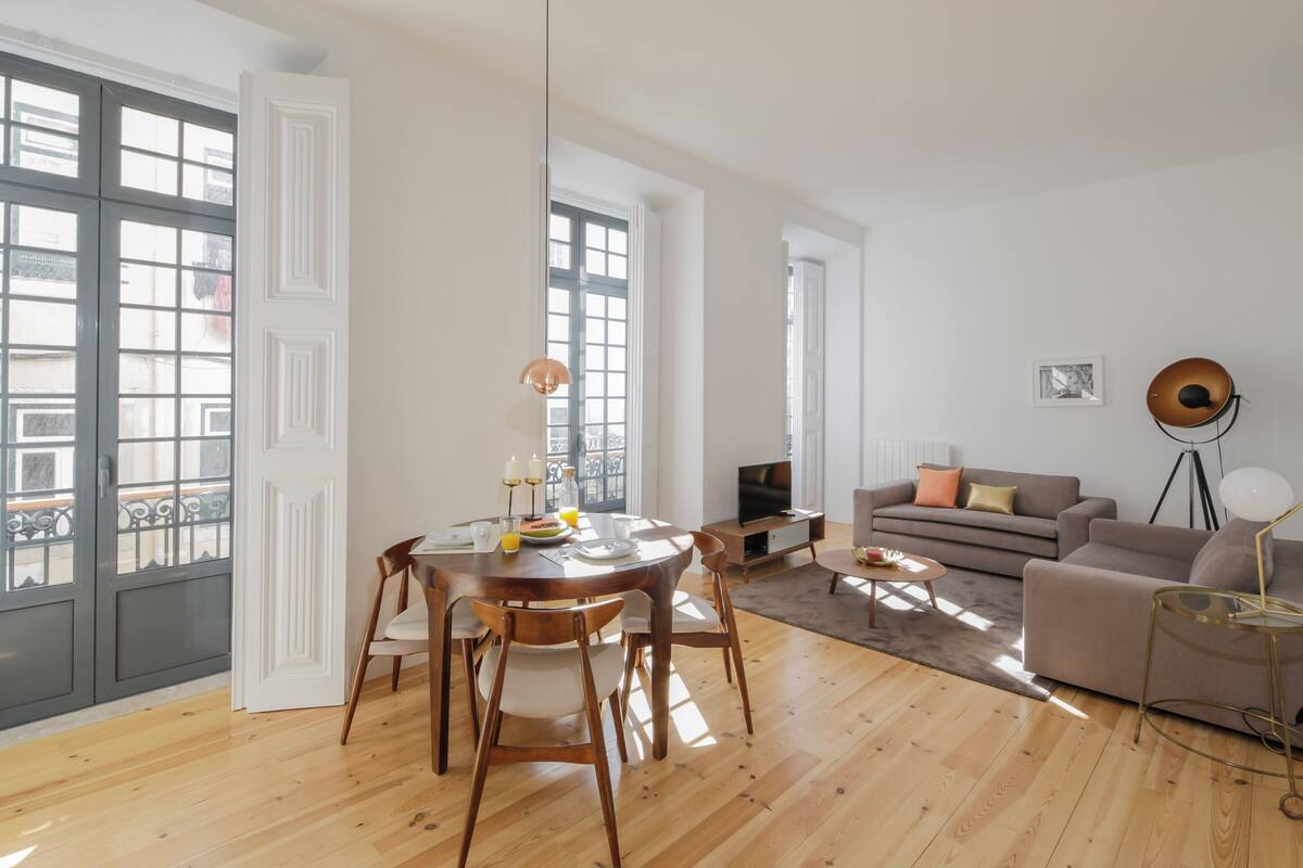 Un vaste espace de vie comprenant une table à manger en bois, un canapé et un téléviseur.