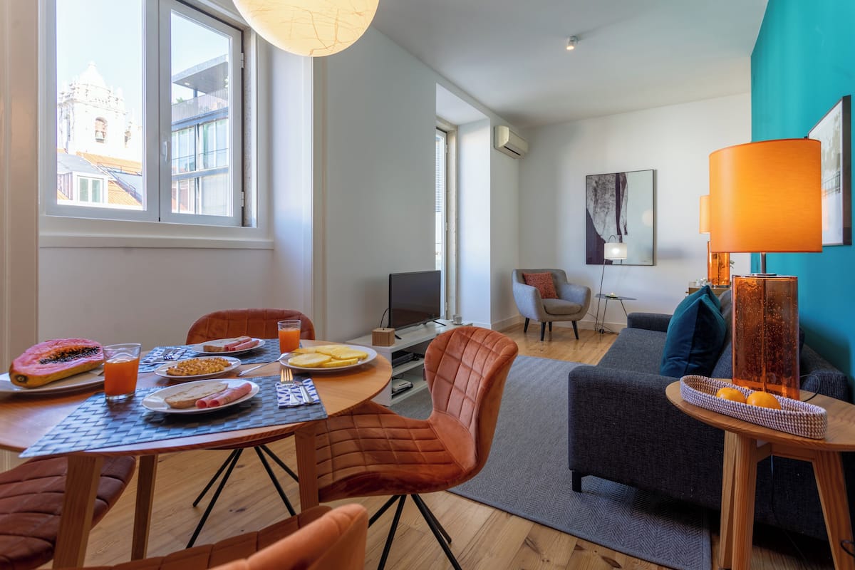 Un salon moderne comprenant un coin repas, un canapé et un téléviseur.