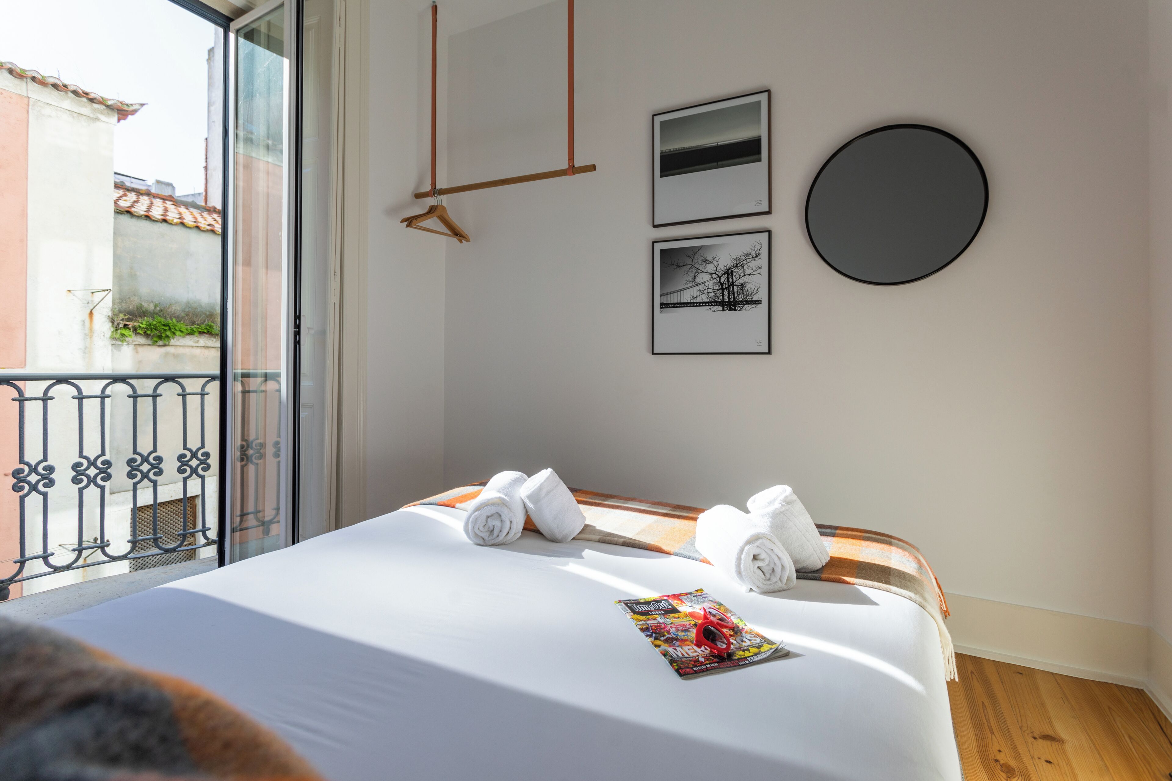Una habitación de hotel con una cama, una revista y dos cuadros colgados en la pared.