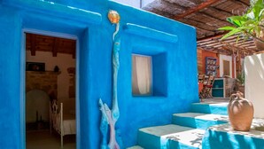 A room with a blue wall, a bed, a window, and a door leading to another room. - Thedreamhouse Chlorinefree Heated Pool Artvillage (Rhodes)