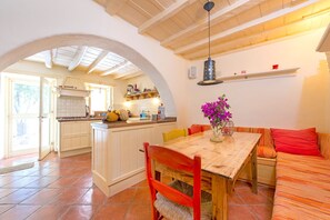A spacious kitchen with an island, a dining area with a wooden table and chairs, and a cozy seating area with a sofa.