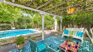 A pool area with a wooden deck, a white outdoor sofa, and potted plants. - Thedreamhouse Chlorinefree Heated Pool Artvillage (Rhodes)
