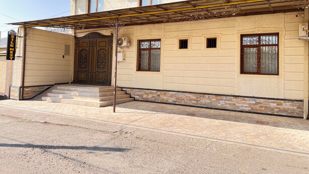 A hotel with a traditional facade, a gated entrance, and a covered walkway. - Silk Nest Hotel (Bukhara)