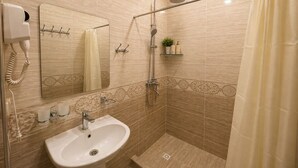 A bathroom with a sink, mirror, shower, and a telephone. - Silk Nest Hotel (Bukhara)