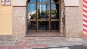 A building entrance with a glass door, a small balcony, and a wheelchair-accessible ramp. - Las Olas Your Retreat in El M Dano (Granadilla de Abona)