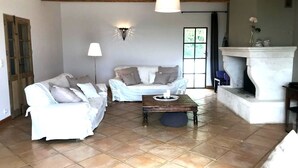 A living room with two white sofas, a coffee table, a fireplace, and a large window. - Maison Roquebeauresse - Piscine privée (Pougnadoresse)