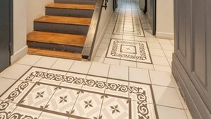 Eine Treppe mit Holzsitzen und einem gemusterten Boden, die zu einer Tür führt.
