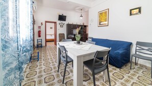 Un comedor con una mesa, sillas y un sofá azul.