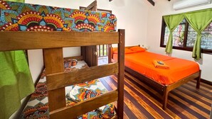A bunk bed with colorful bedding, a ceiling fan, and a window with curtains. - Delfines del Golfo (Puerto Jimenez)