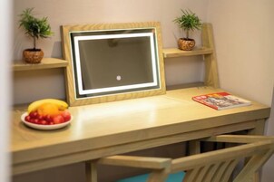 Un escritorio de madera con un marco, un frutero y una revista.