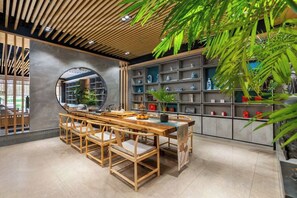 Un intérieur moderne avec une table à manger en bois, des chaises et une bibliothèque intégrée.
