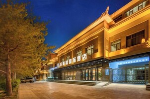 Un hotel de estilo arquitectónico tradicional, con una entrada destacada y una fachada bien iluminada.