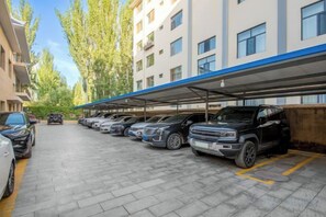 Een parkeerplaats met meerdere auto's en een overdekt gedeelte.