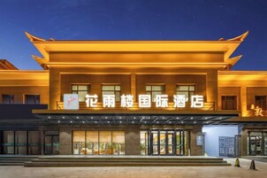 Un hotel de estilo arquitectónico tradicional, con una entrada destacada y un cartel.
