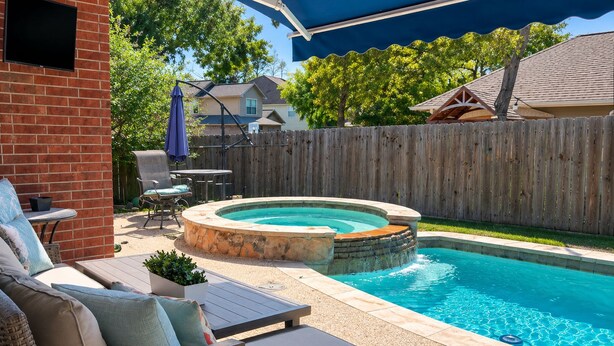 A backyard with a swimming pool, outdoor furniture, and a wooden fence. - House of blue! Beautiful pool, near IAH airport (Humble)
