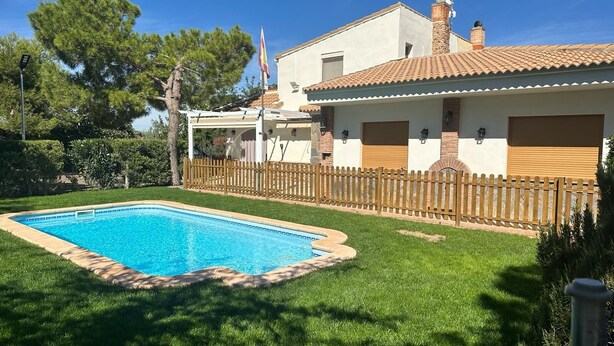 Una casa con piscina, un cortile recintato e una bandiera.