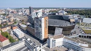 A modern building with a circular central structure, surrounded by rectangular buildings.