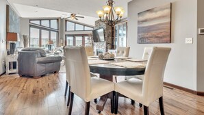A dining area with a round table, chairs, and a chandelier.