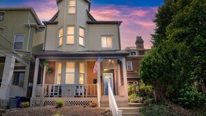 A two-story house with a porch, a flag, and a brick chimney. - 5BDRM GEM with Arcade - Mt Wash (Pittsburgh)