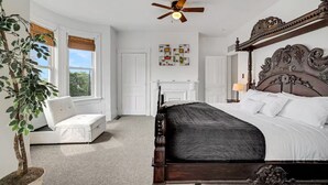 A bedroom with a large bed, a ceiling fan, a white chair, and a potted plant. - 5BDRM GEM with Arcade - Mt Wash (Pittsburgh)