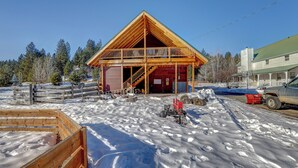 A wooden cabin with a balcony, surrounded by snow and trees. - Sleeps 29!  9-bedroom 8-Bath 3-Kitchen, Historic McBride Farm in Garden Valley (Garden Valley)