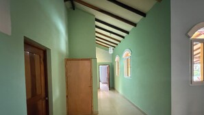 A hallway with green walls, wooden doors, and a tiled floor. - 3-bedroom house in Cool Manzano Número 1 with large pool steps to the Pacific. (El Manzano Número 1)