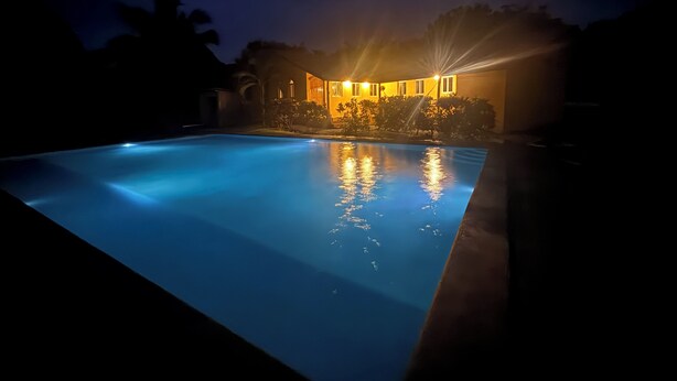 A swimming pool at night with a building in the background. - 3-bedroom house in Cool Manzano Número 1 with large pool steps to the Pacific. (El Manzano Número 1)