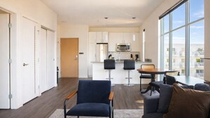 Un apartamento moderno con cocina, comedor y ventanas amplias.