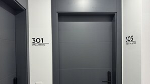 Un ascensor moderno con puerta gris, marcado con el número 301.