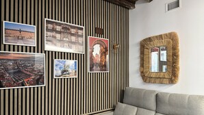 A room with a striped wall, a sofa, and framed photographs.