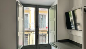 Una cocina con horno empotrado, un fregadero y una ventana con vistas a un balcón.