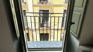 A balcony with a metal railing and a blue mat with white stars.