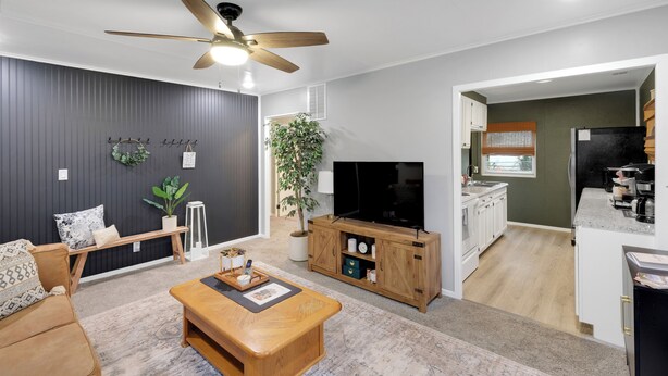 Ein modernes Wohnzimmer mit Sofa, Couchtisch, Fernseher und Holzschrank.