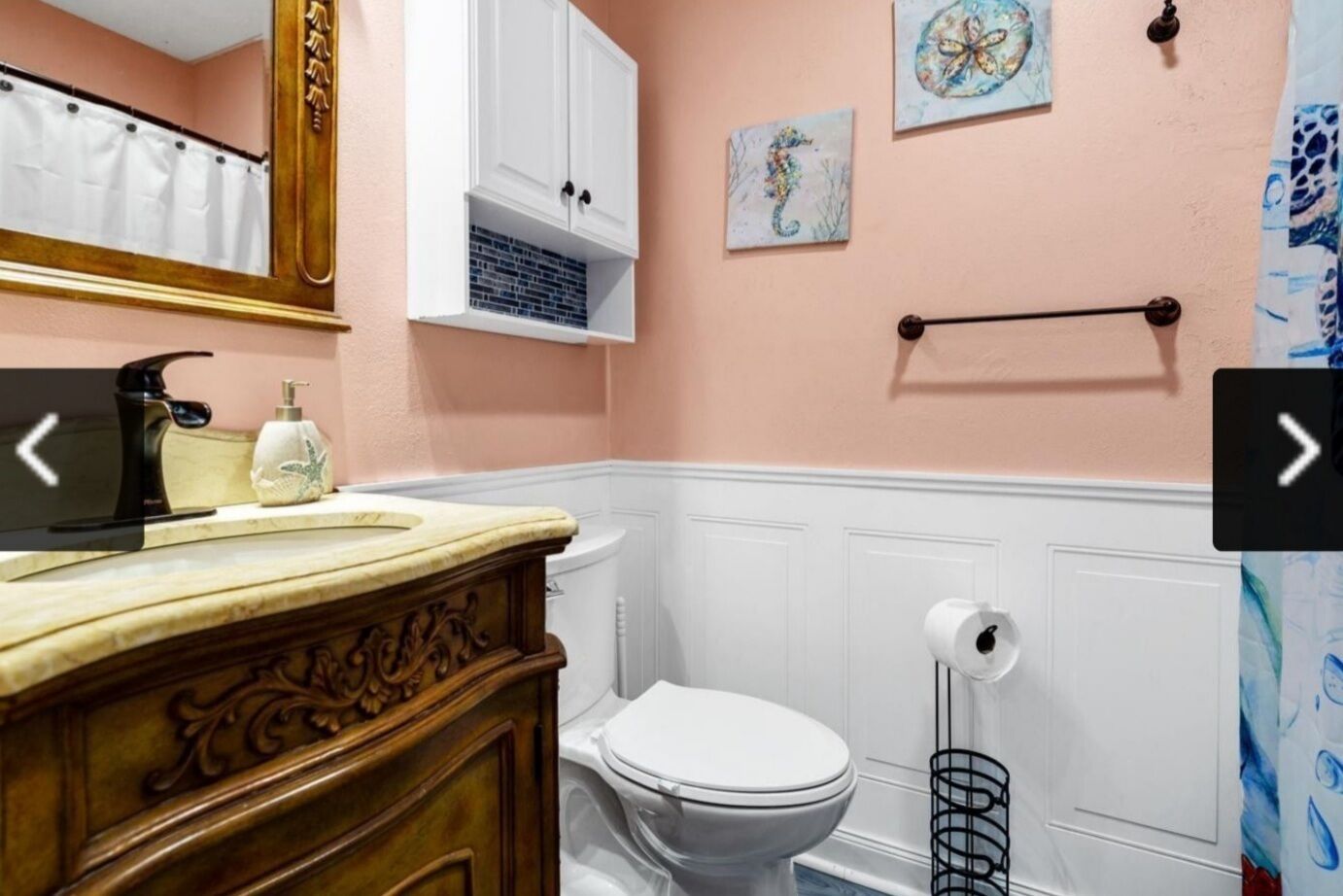 A bathroom with a wooden vanity, a white toilet, and a towel rack.