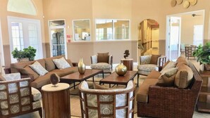 A spacious living area with multiple seating options, including sofas and chairs, arranged around a central coffee table.