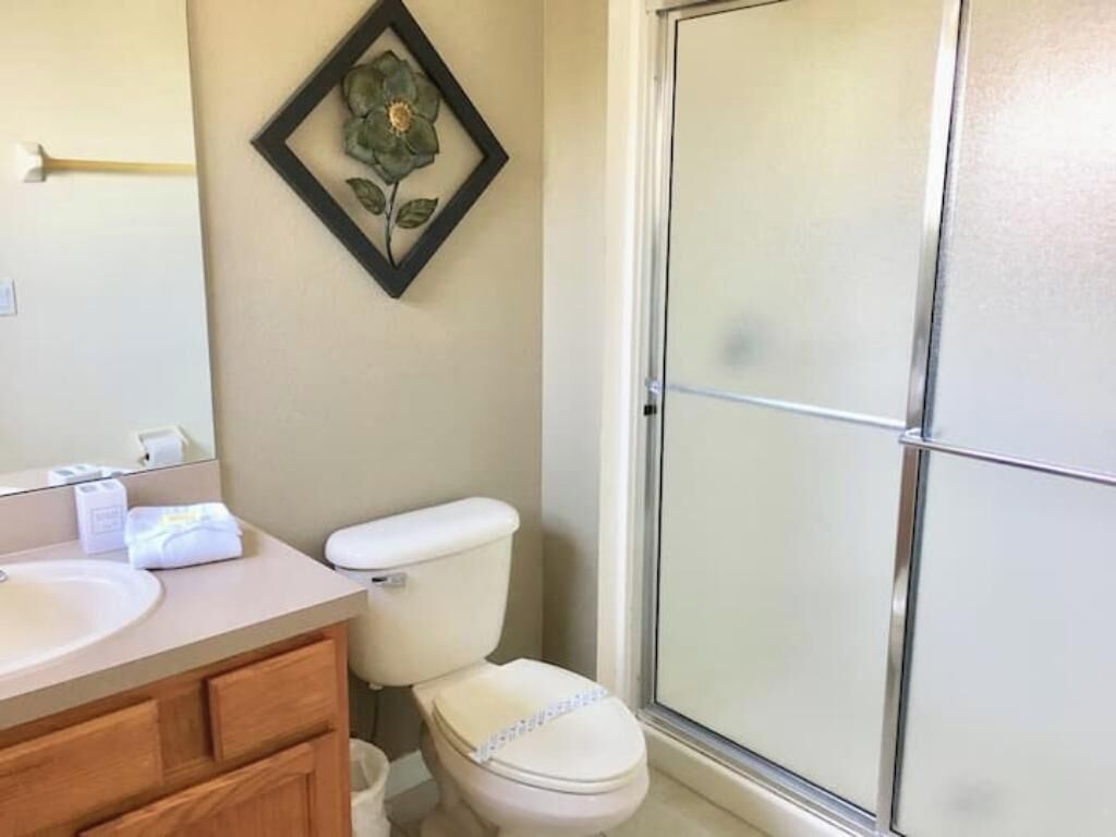 Une salle de bain avec des toilettes, un lavabo et une douche.