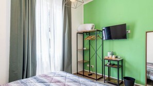 A hotel room with a bed, a wardrobe, a TV, and a small table with items on it. - A Pisa con Amore (Pisa)